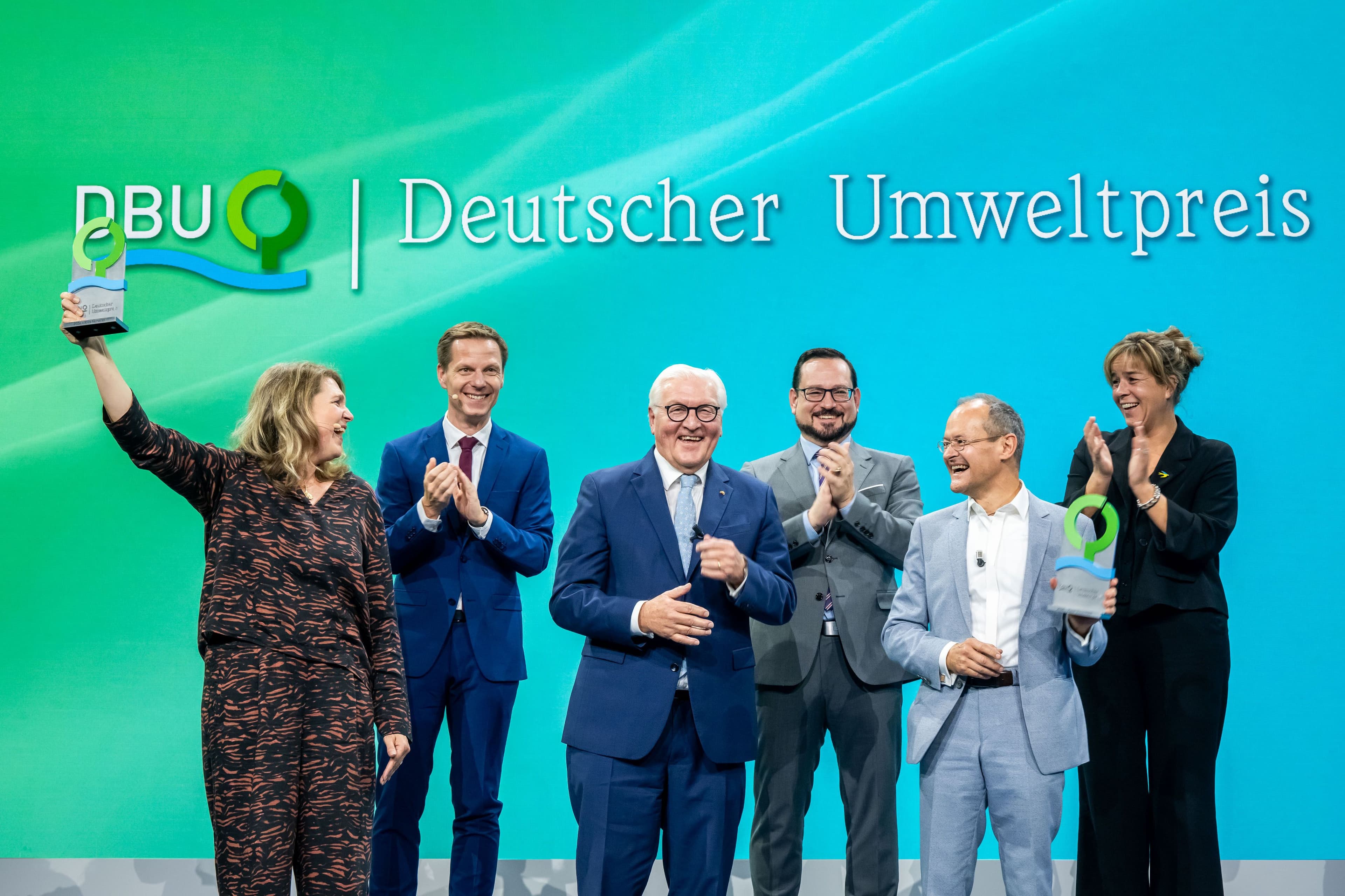 In einem feierlichen Festakt hat die Deutsche Bundesstiftung Umwelt (DBU) heute (Sonntag) den diesjährigen Deutschen Umweltpreis in Höhe von insgesamt 500.000 Euro in Aachen vergeben. Überreicht wurden die Preise von Bundespräsident Frank-Walter Steinmeier (vorne, Mitte) an die Hamburger Umweltjuristin Dr. Roda Verheyen (vorne, links) und Membranfilter-Ingenieur Dr. Klaus Vossenkaul (vorne, rechts). Das Foto zeigt zudem (hinten, von links) den DBU-Kuratoriumsvorsitzenden Kai Niebert, DBU-Generalsekretär Alexander Bonde und NRW-Vize-Ministerpräsidentin Mona Neubaur. Foto: Peter Himsel / DBU