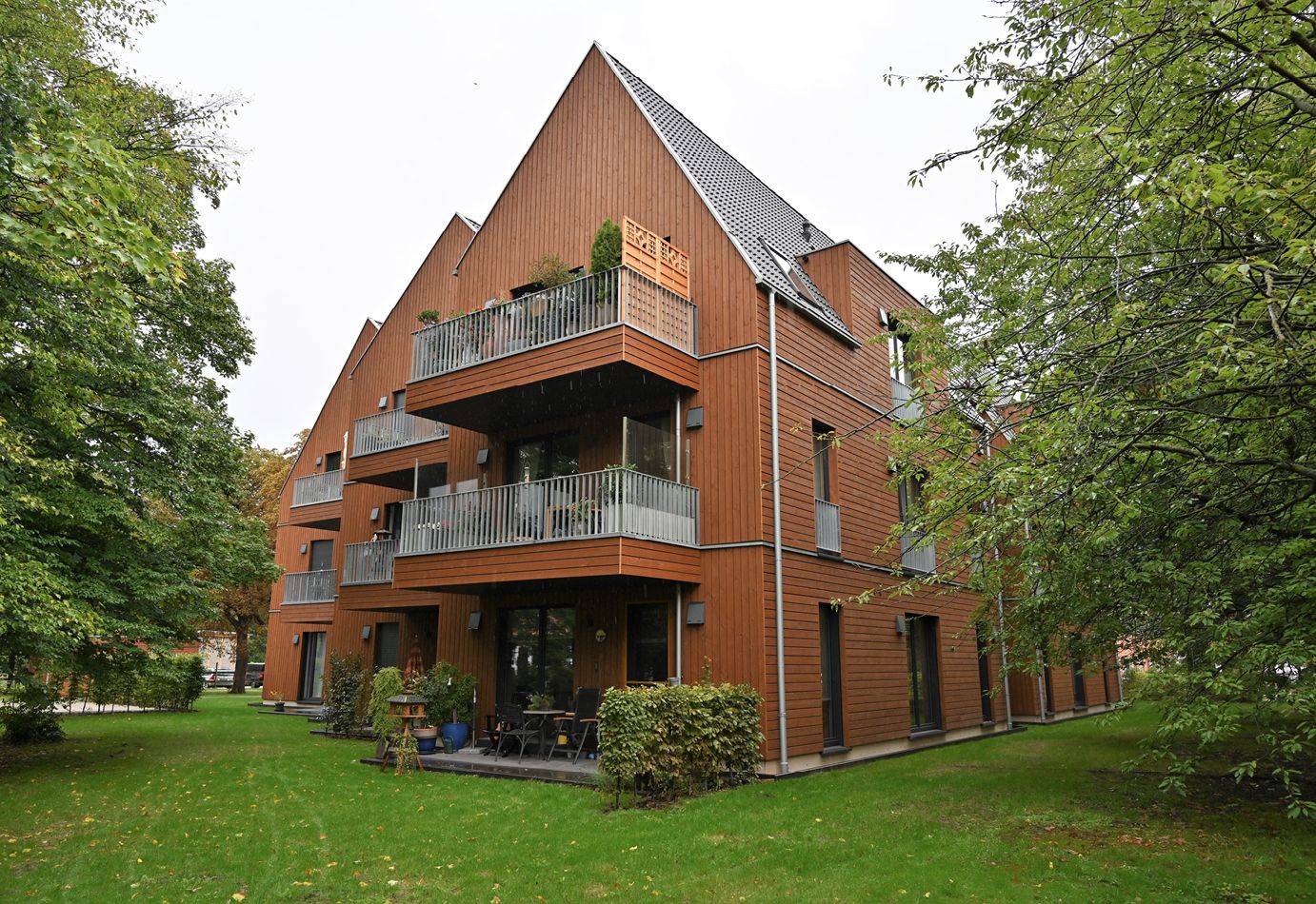 ie Fassade des gegliederten dreigeschossigen Ensembles besteht durchgängig aus kastanienbraun lasiertem Lärchenholz Quelle: DHV/Kahrs Architekten/Achim Dathe