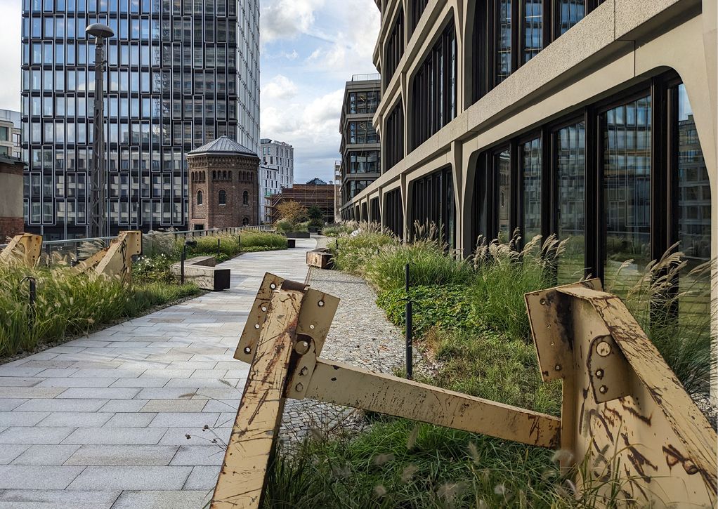 Bild 1 Grüne Wege zwischen moderner Architektur und histo­rischem Mauerwerk: Die intensiv begrünten Dachflächen am Postbahnhof verbinden Aufenthaltsqualität mit wirksamem Regenwassermanagement. (Quelle: Levin Monsigny Landschaftsarchitekten)