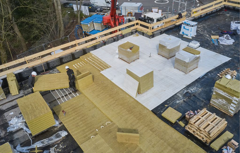 Bild 2 Wärmedämmung, Gefälledachdämmung und abschließende Nutzdachdämmung wurden auf einer Teilfläche des Daches zunächst als optimale Abstellfläche für angelieferte Paletten komplett verlegt. Ausgehend von dieser „Lagerinsel“ erschlossen sich die Dachdecker die übrige Dachfläche. (Fotos: DEUTSCHE ROCKWOOL GmbH & Co. KG)